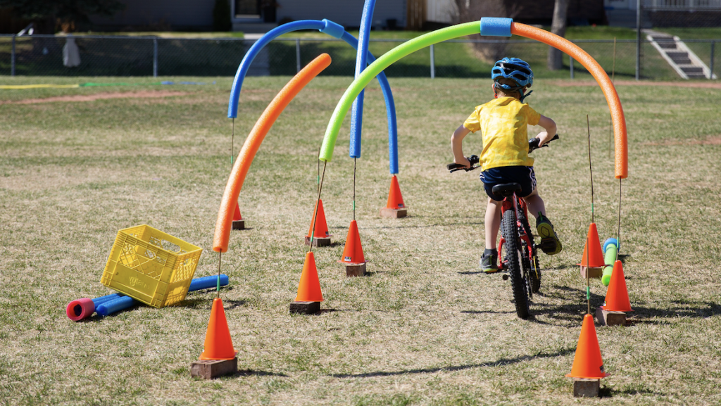 kids on a bike navigating an obsticle course